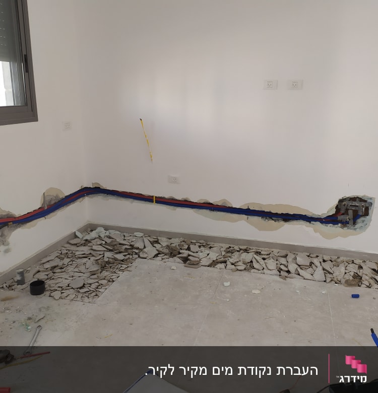 קירות פתוחים עם צינורות צבעוניים וכלי עבודה על הרצפה